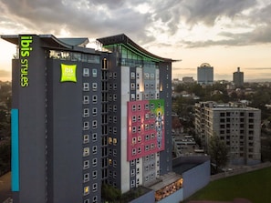 Een hotel met meerdere verdiepingen, met een modern design en een opvallend 'ibis Styles' bord.