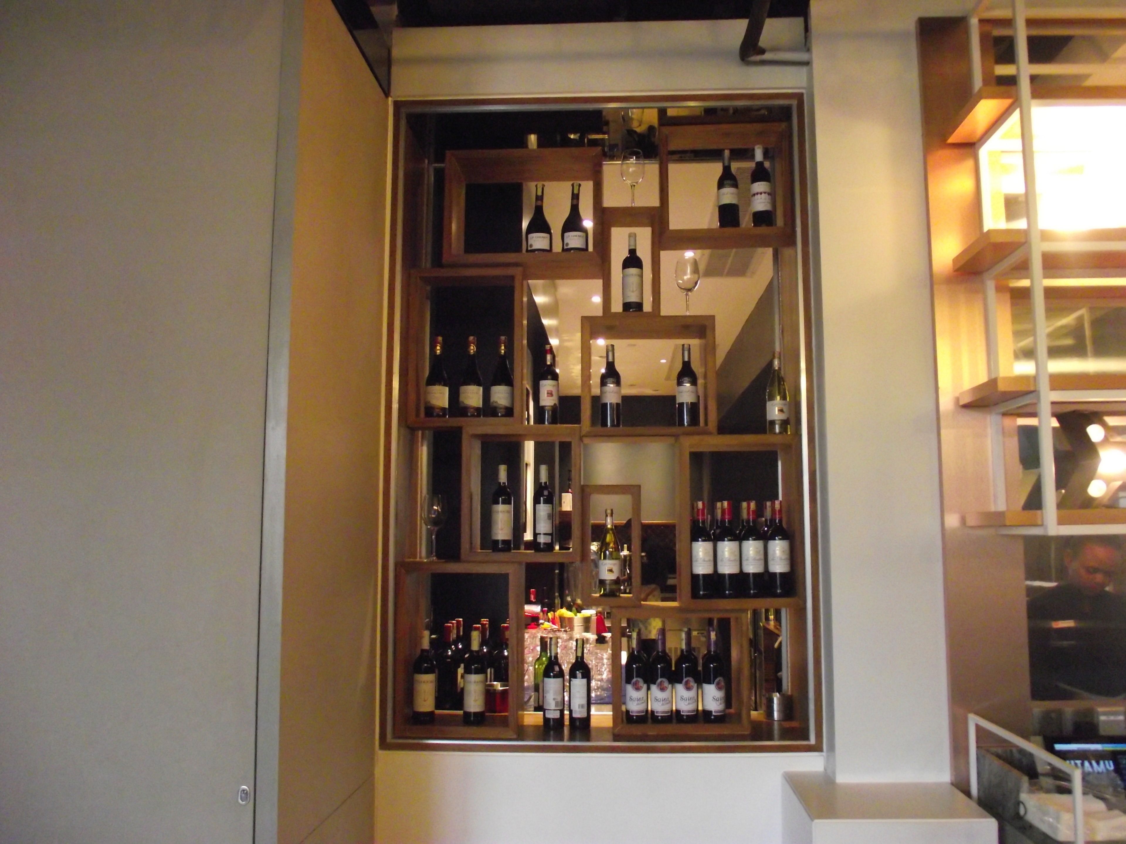 A wine cellar with multiple wooden shelves displaying various wine bottles.