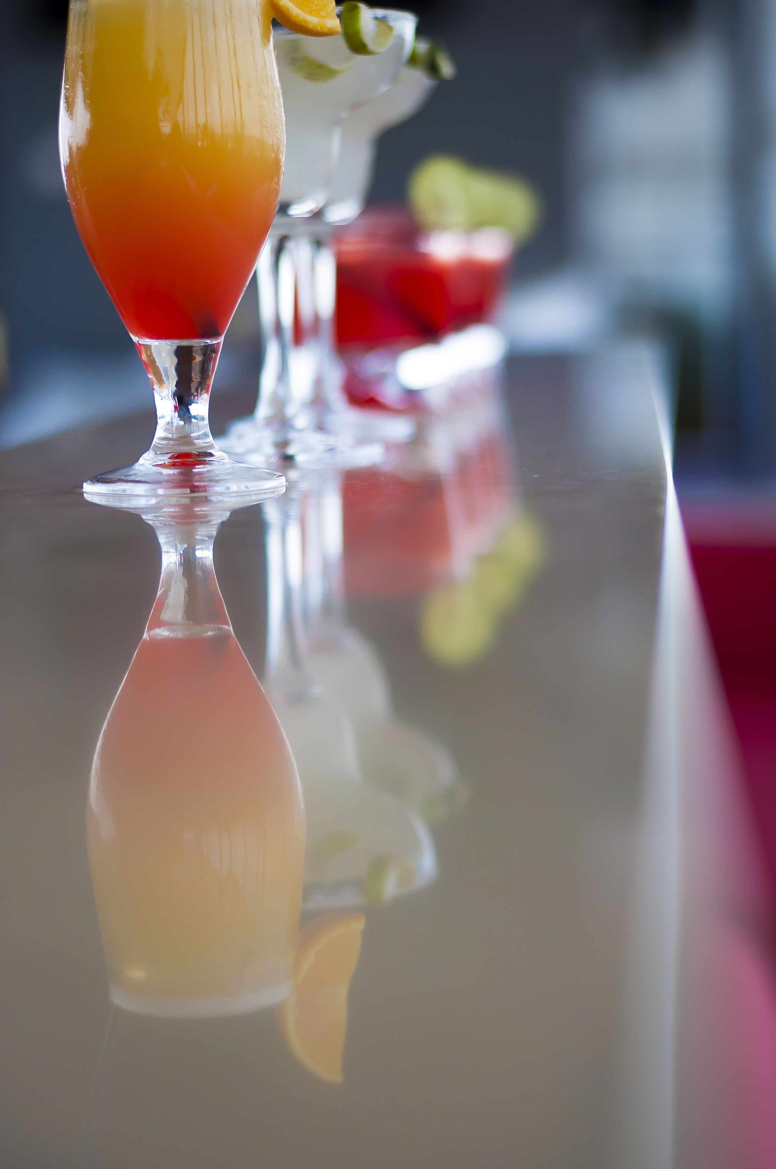 A bar setting with a glass of orange juice and a slice of orange garnish.