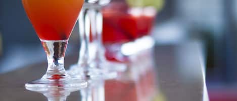 A bar setting with a glass of orange juice and a slice of orange garnish.