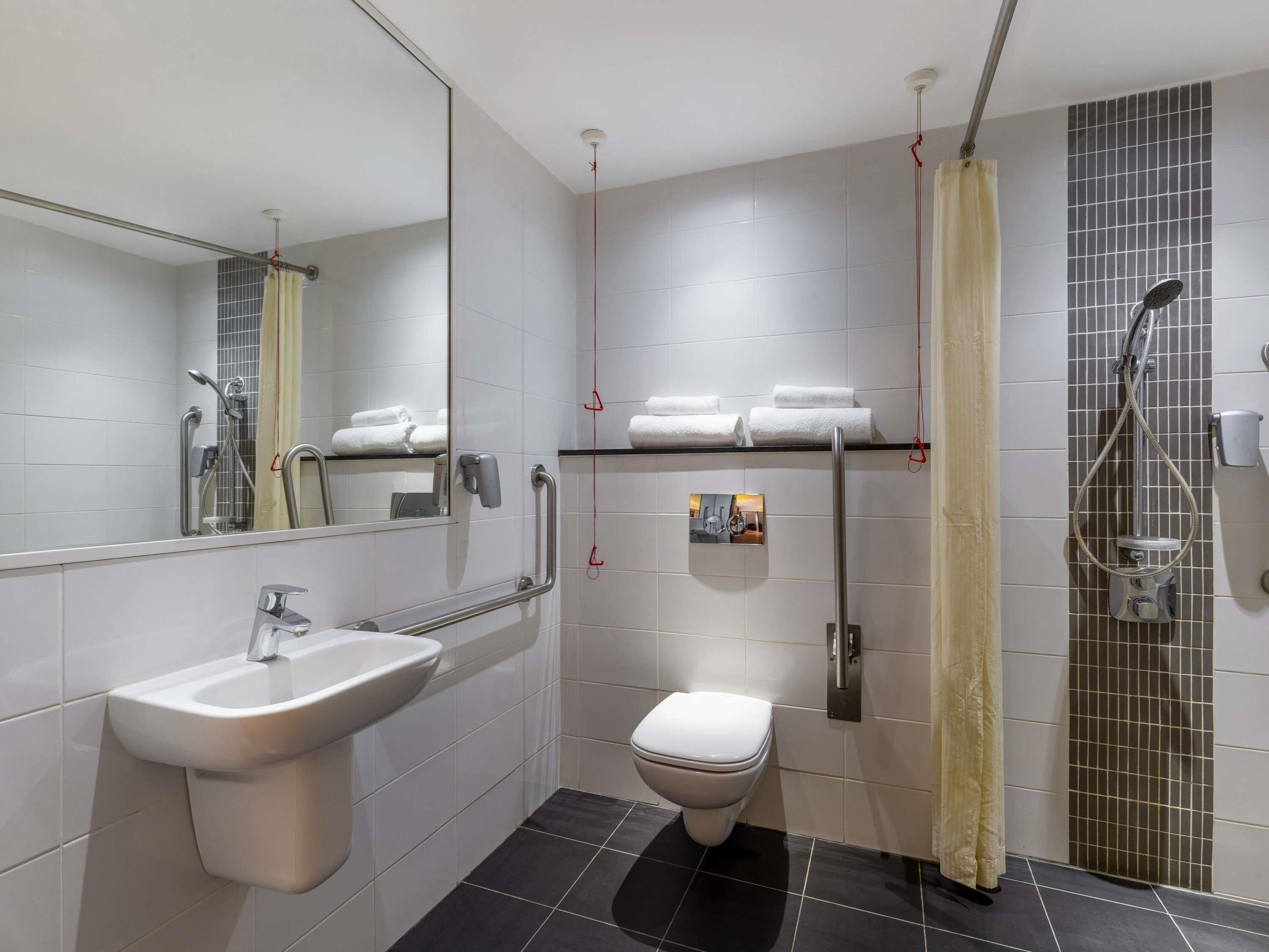 A modern bathroom with a sink, toilet, and shower.