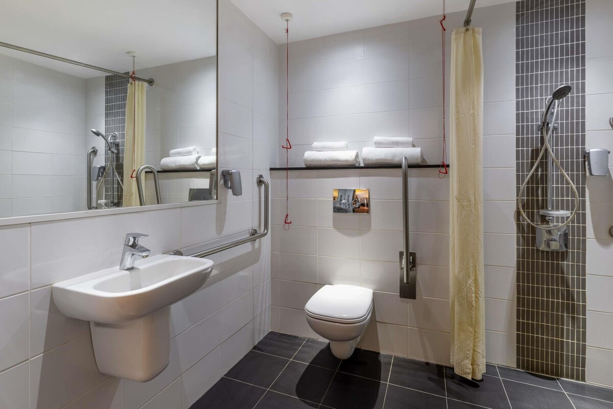 A modern bathroom with a sink, toilet, and shower.