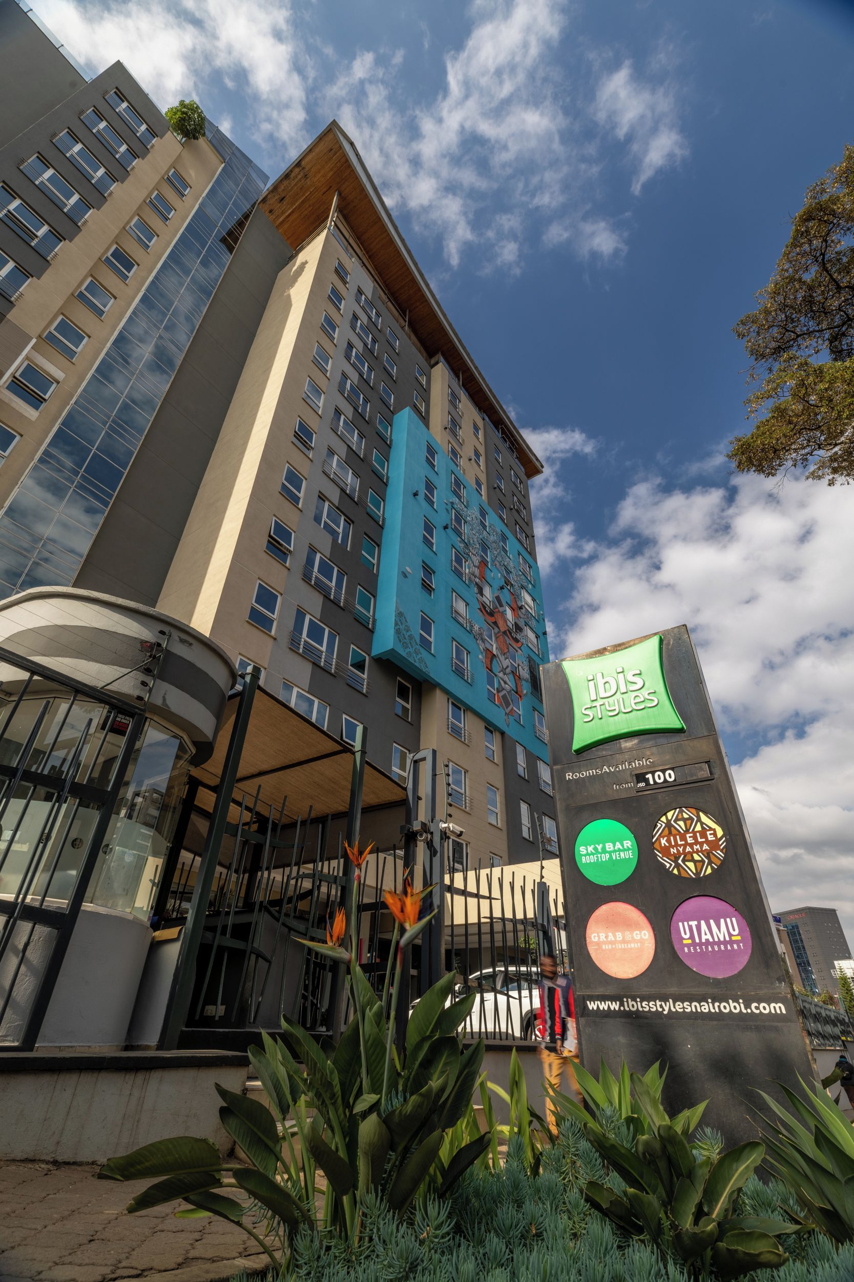 A multi-story hotel with a prominent entrance, a rooftop venue, and various amenities including a sky bar and restaurants.