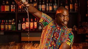 Un barman sirviendo una bebida en una coctelera.