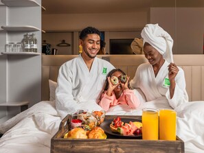 Een hotelkamer met een bed, een ontbijtserver en een televisie op de achtergrond.