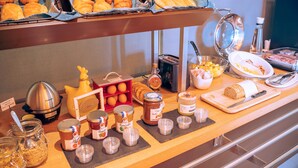 A buffet with various food items including pastries, bread, and condiments. - B&B HOTEL Metz Est Technopole Pôle Santé (Peltre)