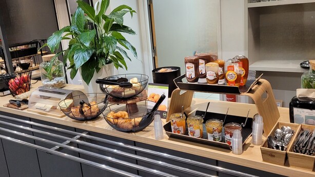 A breakfast buffet with various food items, condiments, and utensils.