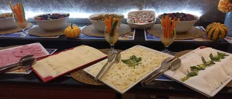 A buffet with various food items and utensils.