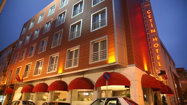 A multi-story hotel with a prominent "CETIN HOTEL" sign, multiple windows, and red awnings. - Cetin Otel (Kesan)