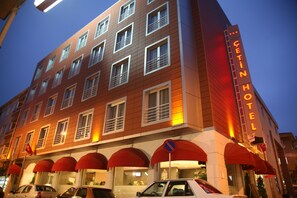 A multi-story hotel with a prominent "CETIN HOTEL" sign, multiple windows, and red awnings. - Cetin Otel (Kesan)