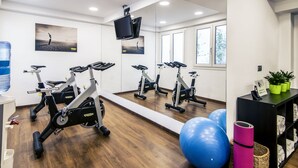 A gym with stationary bikes, exercise balls, and a water dispenser. - Mercure San Sebastian Monte Igueldo (San Sebastián)