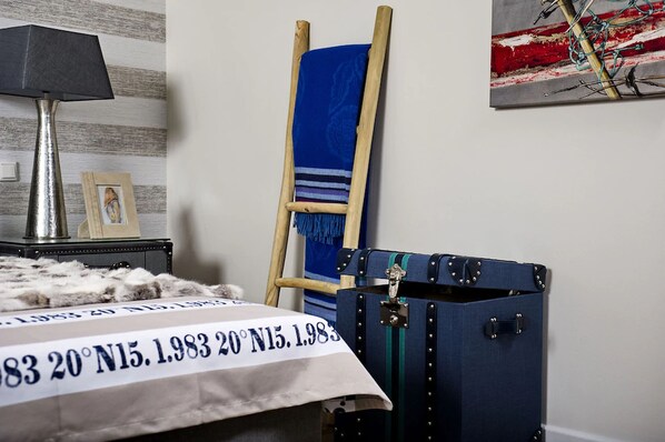 A room with a bed, a wooden ladder, a blue suitcase, and a lamp. - Easy Living Hotel (List)
