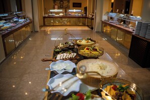 A buffet setup with various food items and a decorative centerpiece. - Gemma Resort (Marsa Alam)