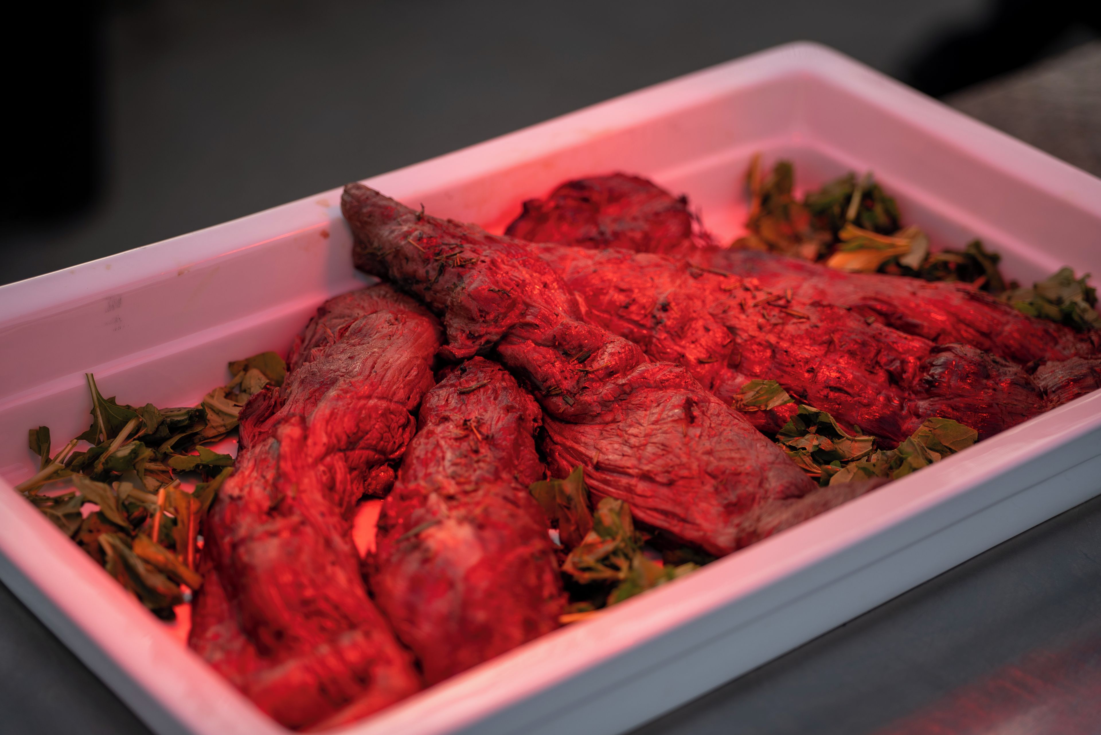 A tray with roasted meat and herbs.