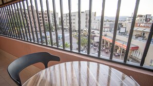A balcony with a view of a cityscape, including buildings and a Popeye's restaurant. - Al-Riyati For Hotel Apartments (Aqaba)