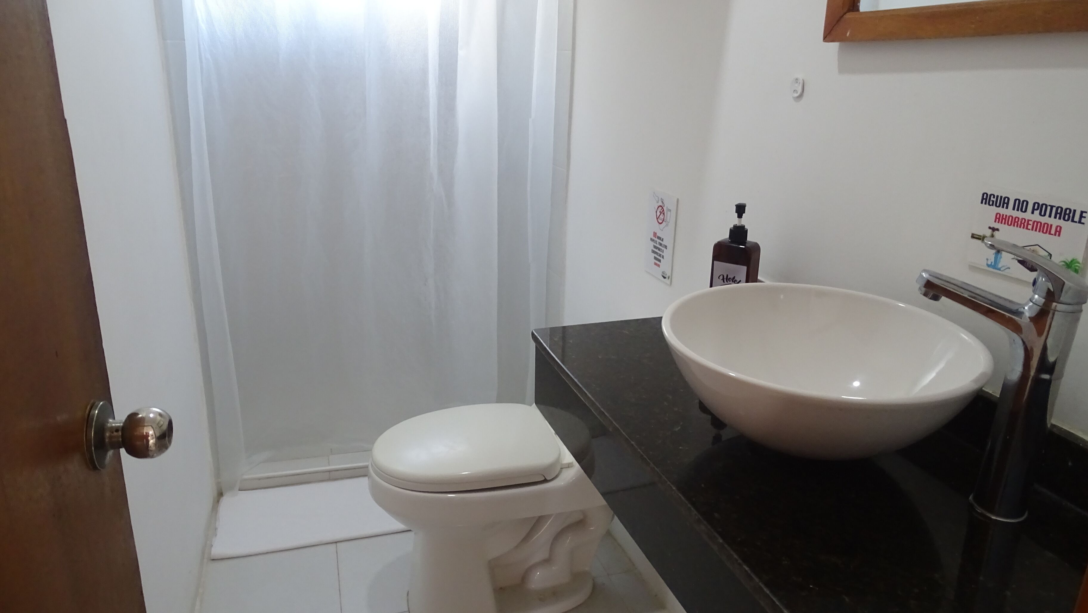 A bathroom with a toilet, a sink, and a shower curtain.