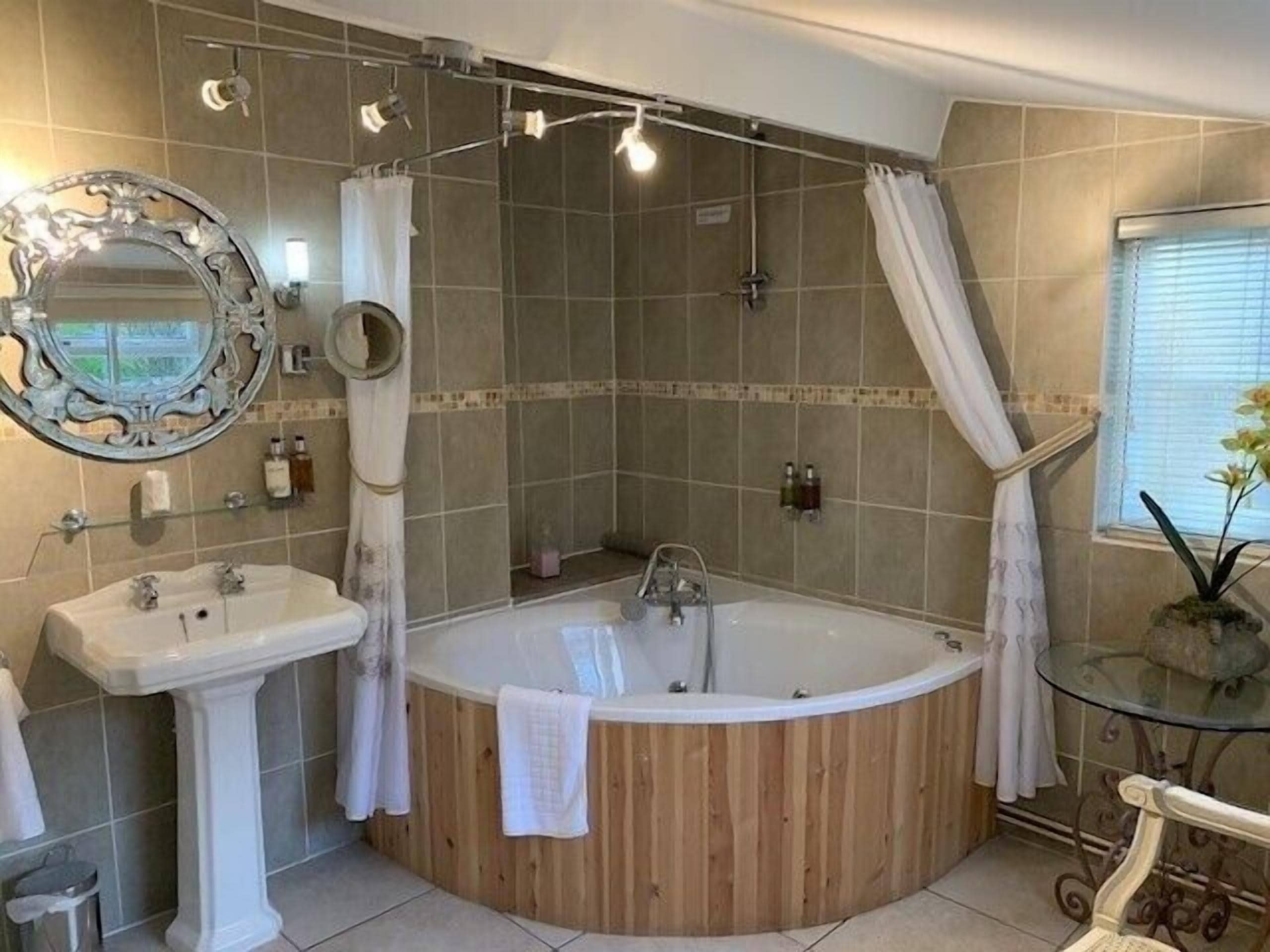 A bathroom with a freestanding bathtub, a pedestal sink, and a shower area.