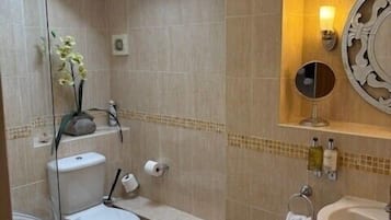 Ein modernes Badezimmer mit Dachfenster, einer Badewanne, einer Toilette und einem Waschbecken.