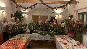 A room with a long table decorated for a festive occasion, featuring garlands and greenery. - Old White Hart (Oakham)