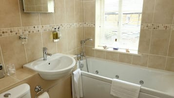 A bathroom with a toilet, sink, and bathtub.