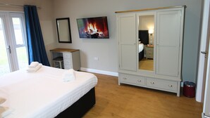 Una camera da letto con un letto, un armadio, uno specchio e un'immagine di un camino appesa al muro.