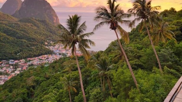A view of a coastal town with palm trees and mountains in the background. - Samfi Gardens (Soufrière)