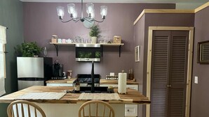 Una cocina con una isla central, sillas de madera, un refrigerador de acero inoxidable, un microondas y una estufa a gas.