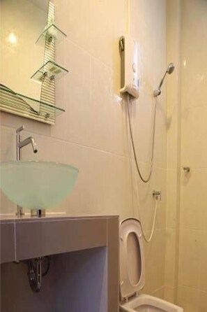 A bathroom with a glass bowl sink, a handheld showerhead, and a toilet. - Bai Pai Resort (Khlung)