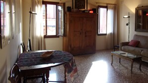 A living room with a wooden ceiling, a dining table with chairs, a sofa, and a coffee table. - A quiet corner in the "True Venice" (venezia)