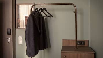 A bathroom with a wooden cabinet, a towel rack with a towel, and a mirror.