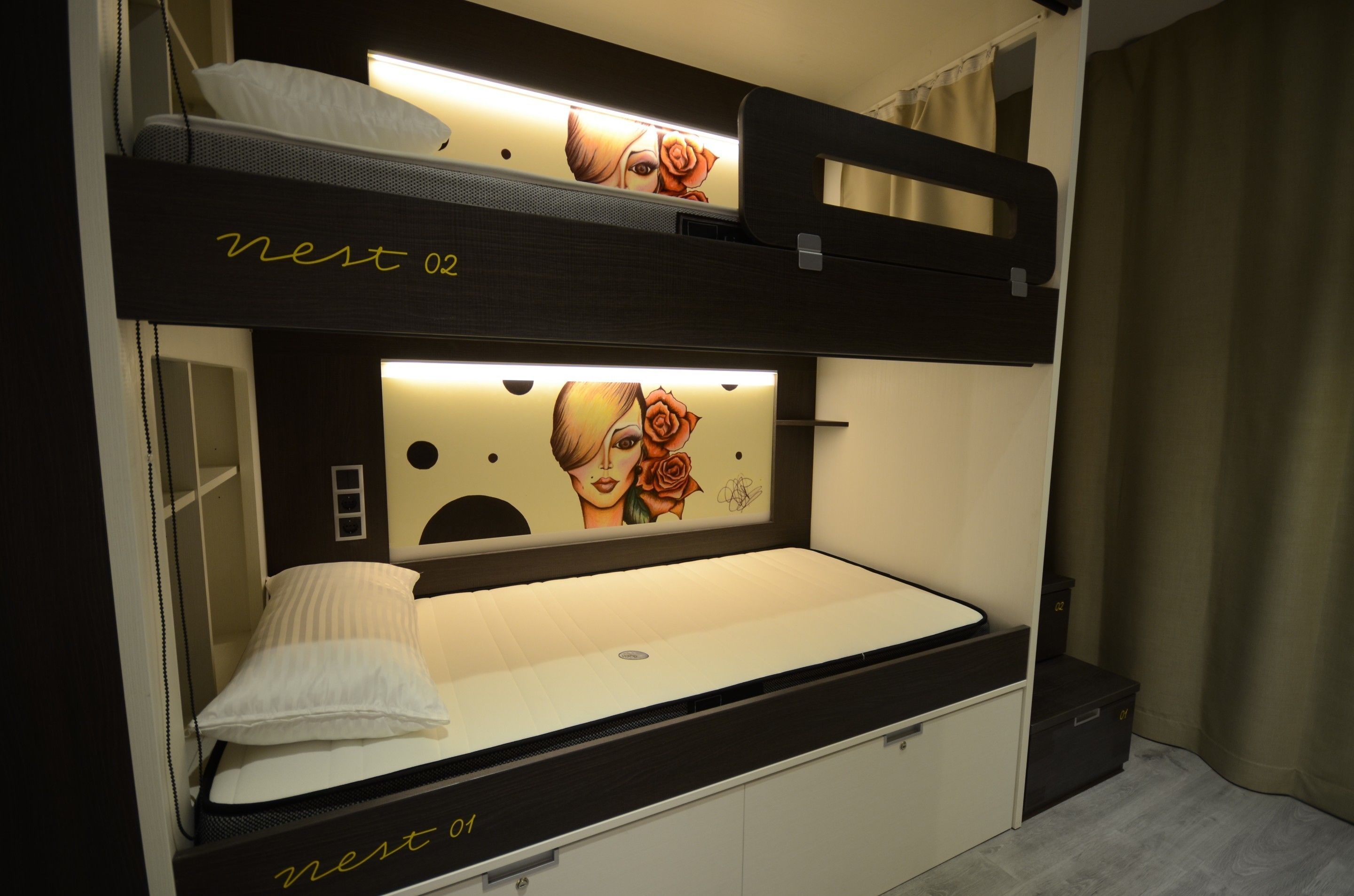 A bunk bed with a headboard featuring a graphic design and a bedside table.