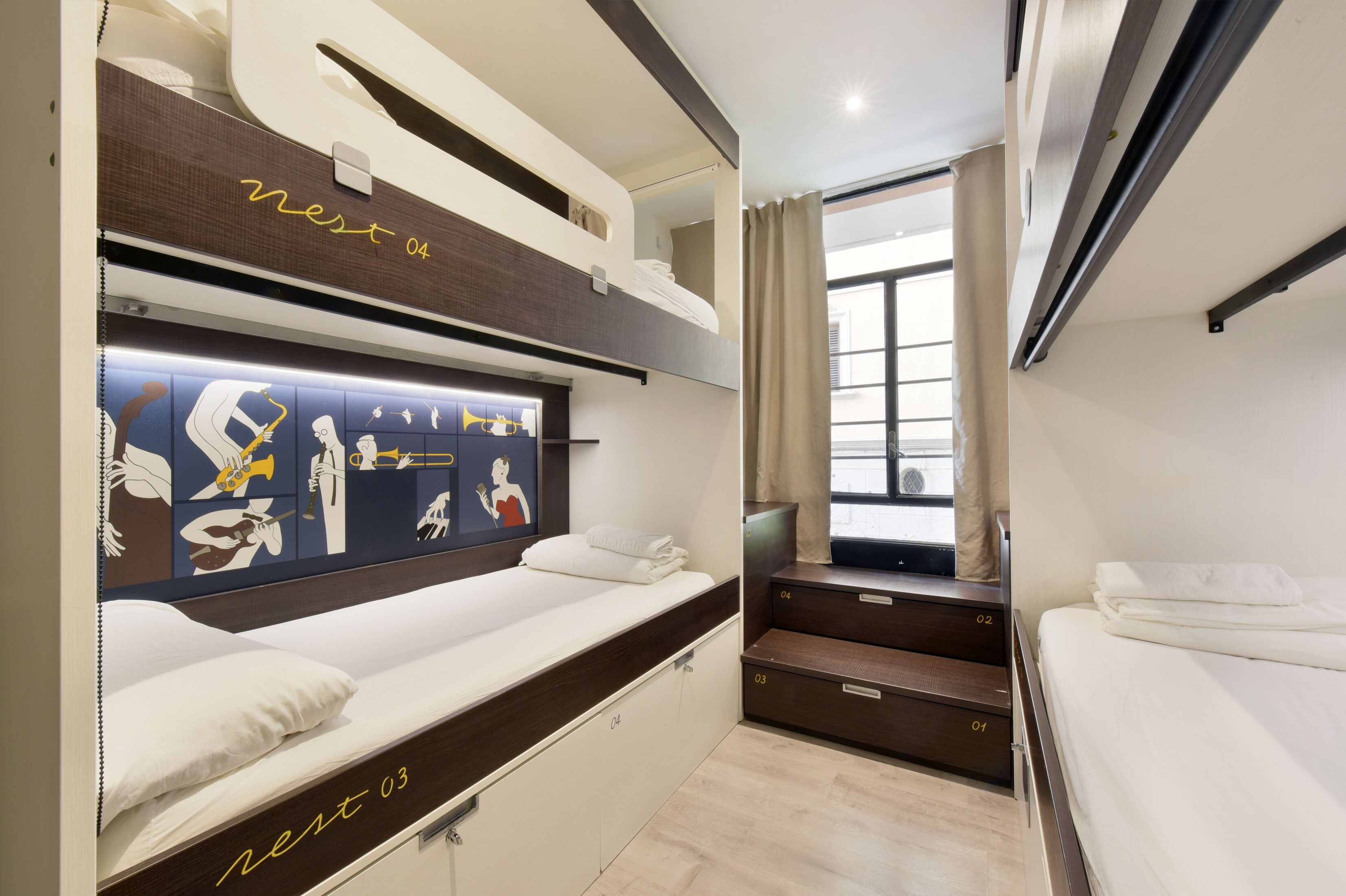 Dormitorio con literas, un mural, una ventana con cortinas y una escalera.