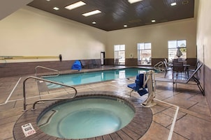 Piscina interna com hidromassagem, área de estar e corrimãos de segurança.