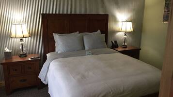 Ein Hotelzimmer mit einem großen Bett, zwei Nachttischen und Lampen.