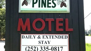 A motel sign with the name "The Whistling Pines" and a phone number (252) 335-0817. - Whistling Pines - Daily & Extended Stay, Elizabeth City (Elizabeth City)