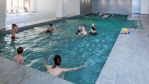 An indoor swimming pool with multiple lanes, tiled walls, and a clear view of the pool area. - Chalet in Paradiski with Pool & Spa (Plagne Villages)