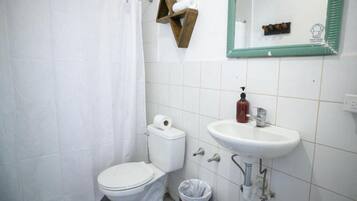 Une salle de bain avec des toilettes, un lavabo et un miroir.