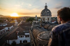 A historic building with a dome and a statue, overlooking a street with colonial architecture. - Socialtel Granada (Granada)