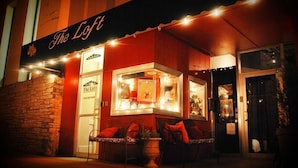 Un edificio con un letrero que dice "The Loft" y un escaparate de vidrio que muestra varios artículos.