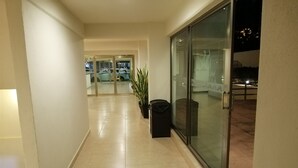A corridor with a glass door leading to a balcony. - Misol-Ha Hotel Mérida (Mérida)