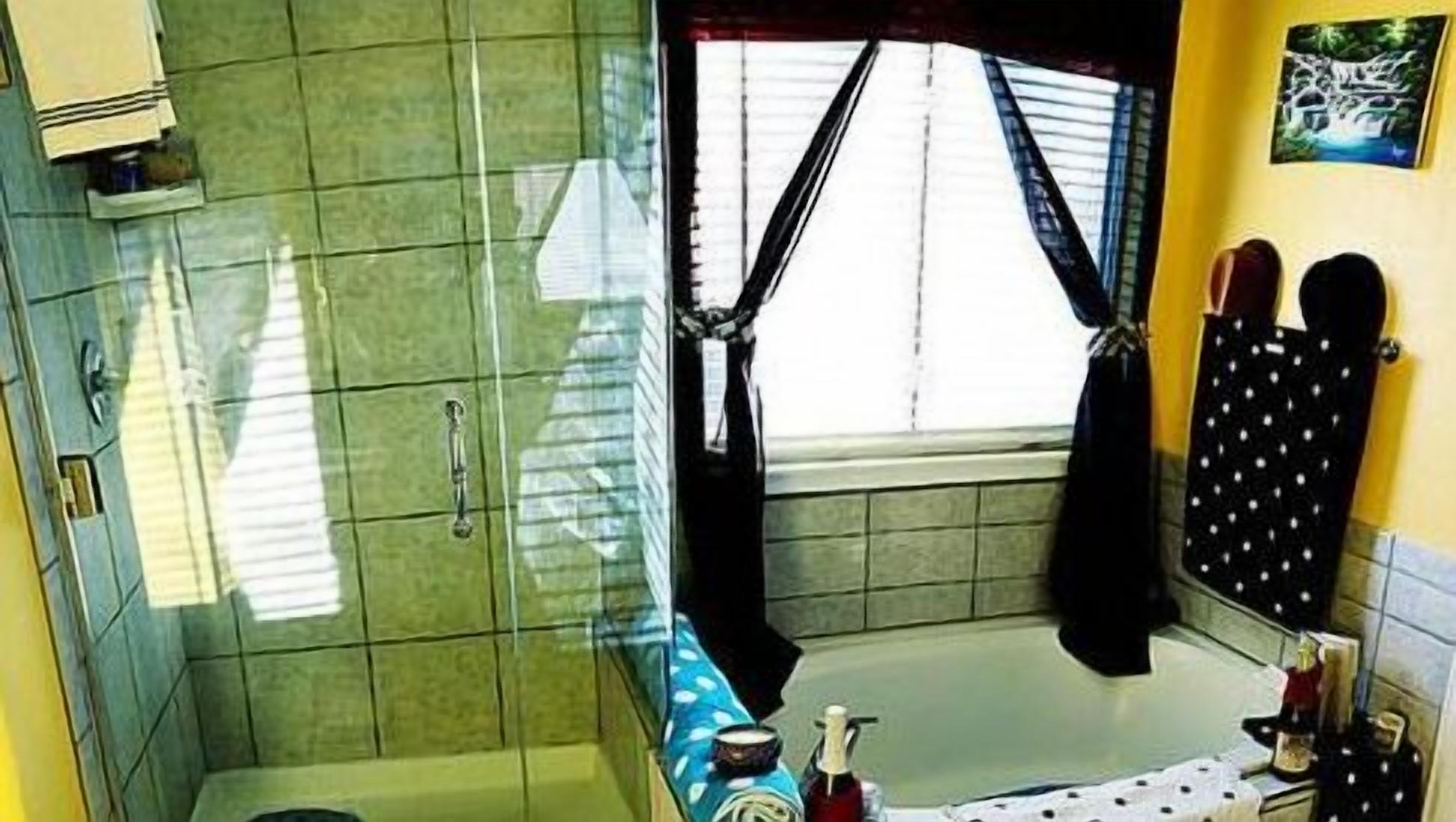 Een badkamer met een douche, wastafel en toilet.