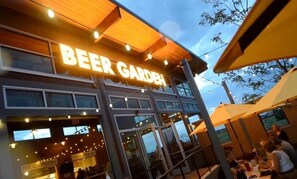 A building with a sign reading "BEER GARDEN" and a food pickup area.