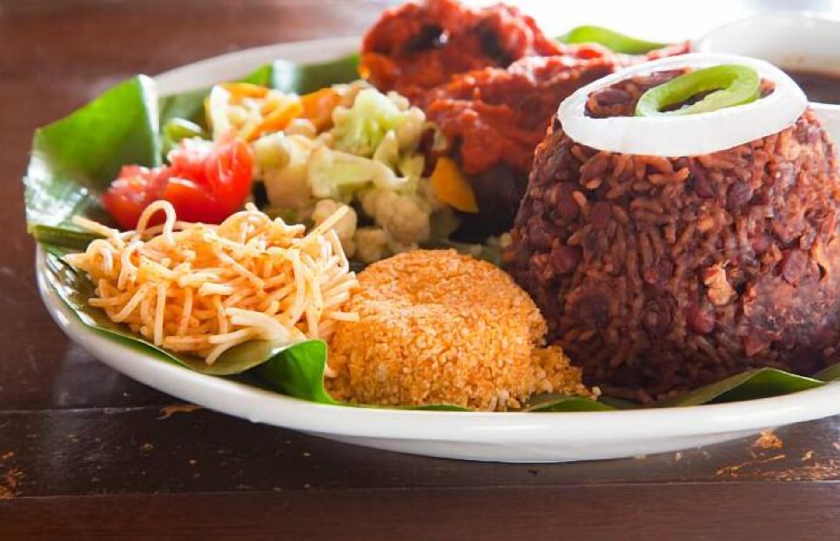Une assiette de nourriture comprenant du riz, des légumes et un plat frit.