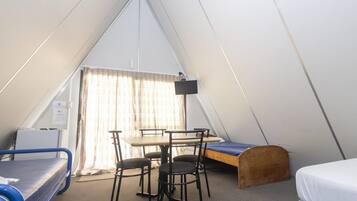 Una tienda de campaña con una cama, una mesa y sillas.