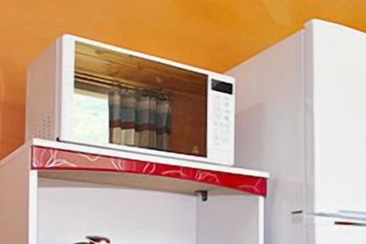 A white refrigerator with a microwave on top.