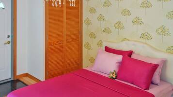 Un dormitorio con una cama, un armario de madera y una pared con estampado de árbol.