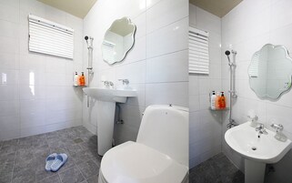 Un baño con azulejos blancos, un inodoro, un lavamanos y una ducha.