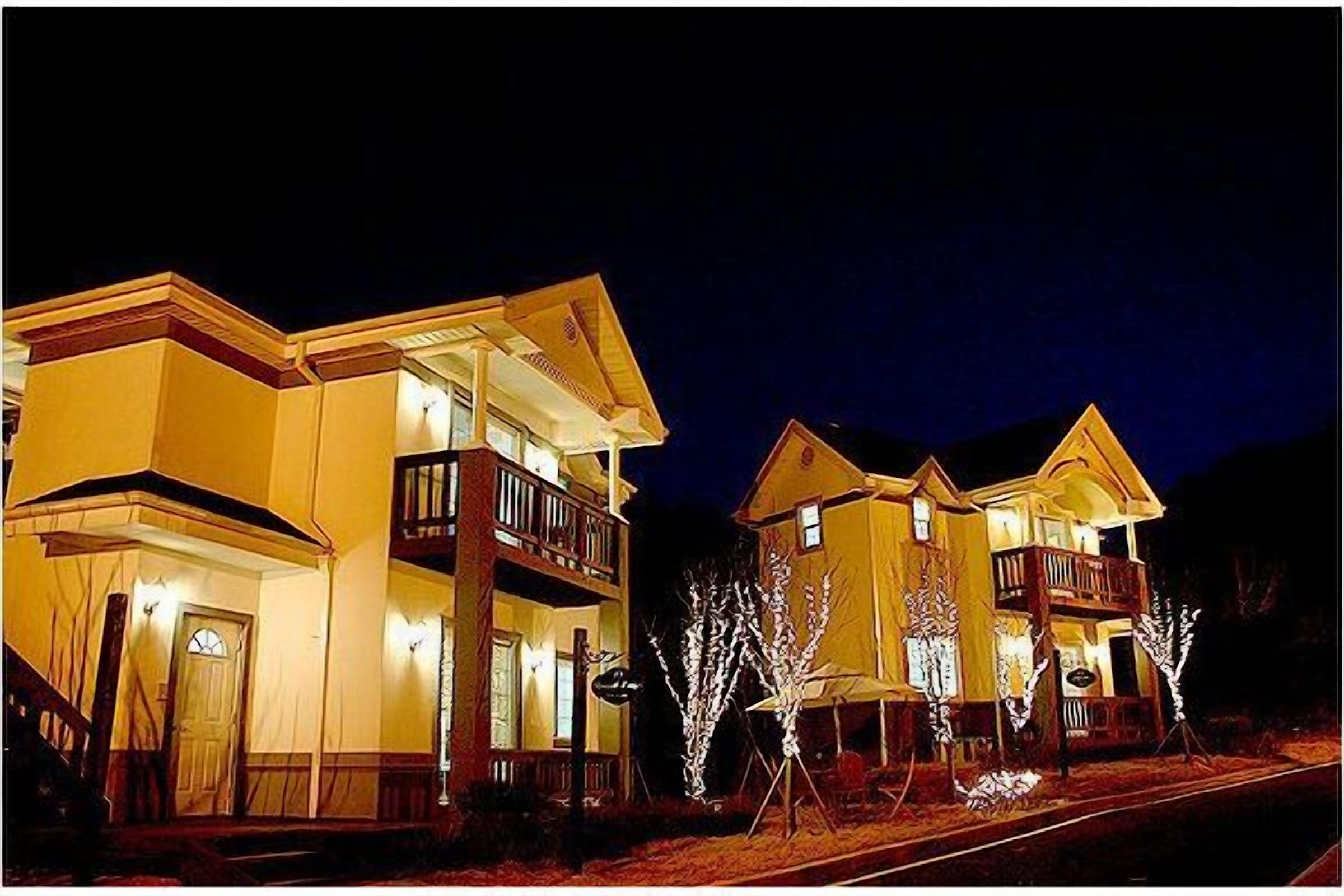 A two-story building with a balcony on the second floor, a front door, and a staircase leading to the entrance.