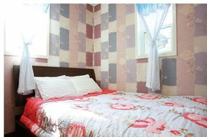 A bedroom with a bed, floral-patterned curtains, and a window with a view.