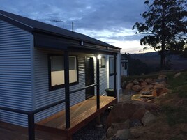 Una casa móvil moderna con terraza de madera y ventanas amplias.